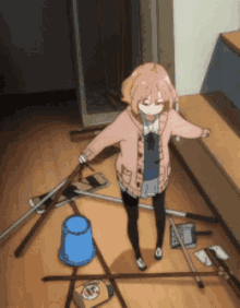 a girl is standing in a messy room with a mop and bucket