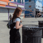 a woman is standing in front of a building that says world is curved