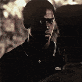 a man wearing a black polo shirt with a lacoste logo