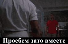 a man in a red shirt is standing in front of another man in a white shirt