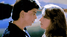 a man and a woman are looking at each other with their eyes closed