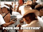 a man in a cowboy hat says pour me somethin ' in a crowd