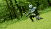 a man in a futuristic costume is kneeling in the grass
