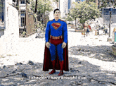 a man in a superman costume is standing on a sidewalk and says " i shouldn t have brought it up "