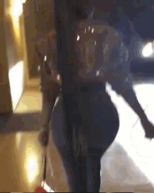 a woman is walking down a hallway with a broom .