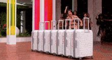 a woman in a bikini is standing in a row of suitcases .