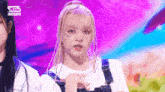 a girl with braids on her face is standing on a stage with other girls .