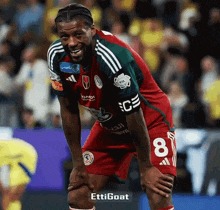 a soccer player with the number 8 on his shorts looks down