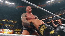 a man in a wrestling ring with a referee and a sign that says martial arts on it