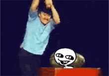 a man in a blue shirt is jumping in the air while a cartoon character looks on