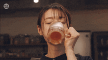 a woman drinking from a glass with a chinese symbol on it