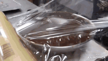 a bowl of chocolate is wrapped in plastic wrap with the words made in animatica below it