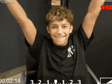 a young man is smiling with his arms in the air and the time of 02:14 is displayed