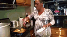 a woman in a white and black dress is cooking on the stove