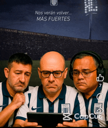 three men are looking at a tablet with the caption nos veran volver