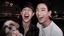 two young men are laughing while holding a small dog and the word got7 is on the bottom