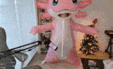 a person in an inflatable axolotl costume stands in front of a microphone