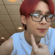 a man with red hair wearing glasses and earrings