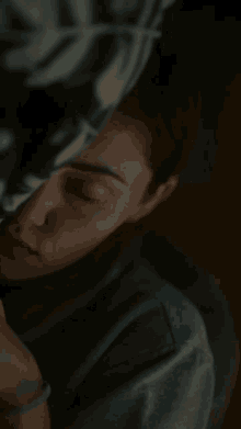 a woman is sleeping with her eyes closed and her hand on her face