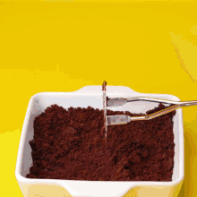 a white casserole dish filled with chocolate crumbs and a spatula