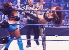 a group of women are wrestling in a ring with a referee .
