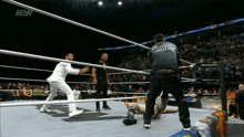 a wrestler is laying on the ground in a ring with the aew logo on the bottom right