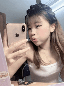 a girl is taking a picture of herself with her iphone