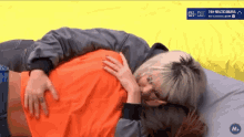 a person laying on a bed with a sign that says 24h multicamara on it