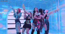 a group of girls are holding water guns in their hands while dancing on a stage .