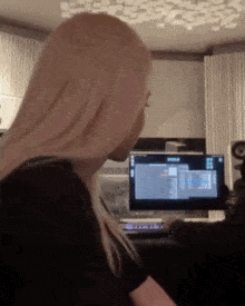 a woman is sitting in front of a computer screen that says ' i 'm sorry ' on it