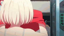 a woman with white hair and a red shirt is sitting in a chair in front of a monitor