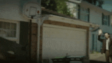 a man standing in front of a garage with a green garbage can that says cle bath on it