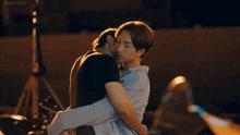 two men are hugging and kissing with the word kiss on the bottom right