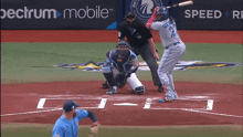 a baseball game is being played in front of a spectrum mobile banner