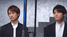 two men are standing next to each other and one of them has a red lip