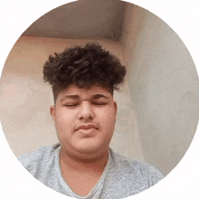 a young man with curly hair is making a funny face in a circle .