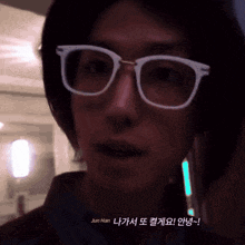 a close up of a person wearing glasses with jun han written below them