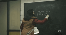 a man is writing on a blackboard with the word pole written on it