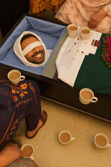 a man in a coffin with his eyes closed is smiling