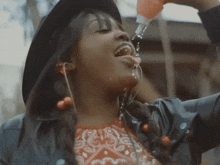 a woman drinking water from a bottle with her tongue sticking out