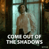 a man standing in front of a window with the words come out of the shadows written below him