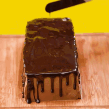 a loaf of chocolate cake is being covered in chocolate