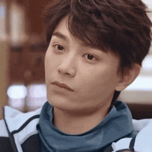 a close up of a young man 's face with a serious look on his face