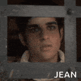 a man with long hair and a beard is wearing a jean shirt and smiling .