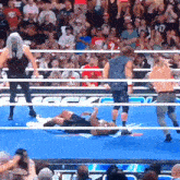 a wrestler is laying on the floor in a ring with a sign that says ' rock ' on it