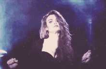a woman is singing into a microphone on a stage