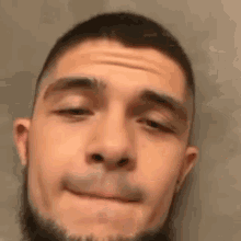 a close up of a man 's face with a beard making a face .