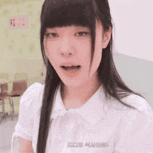 a girl with long hair and bangs is wearing a white shirt that says ed on it