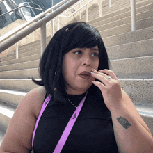 a woman wearing a lanyard that says ' aep ' on it is smoking a cigarette