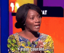 a woman in a yellow and blue shirt says ya pas courant